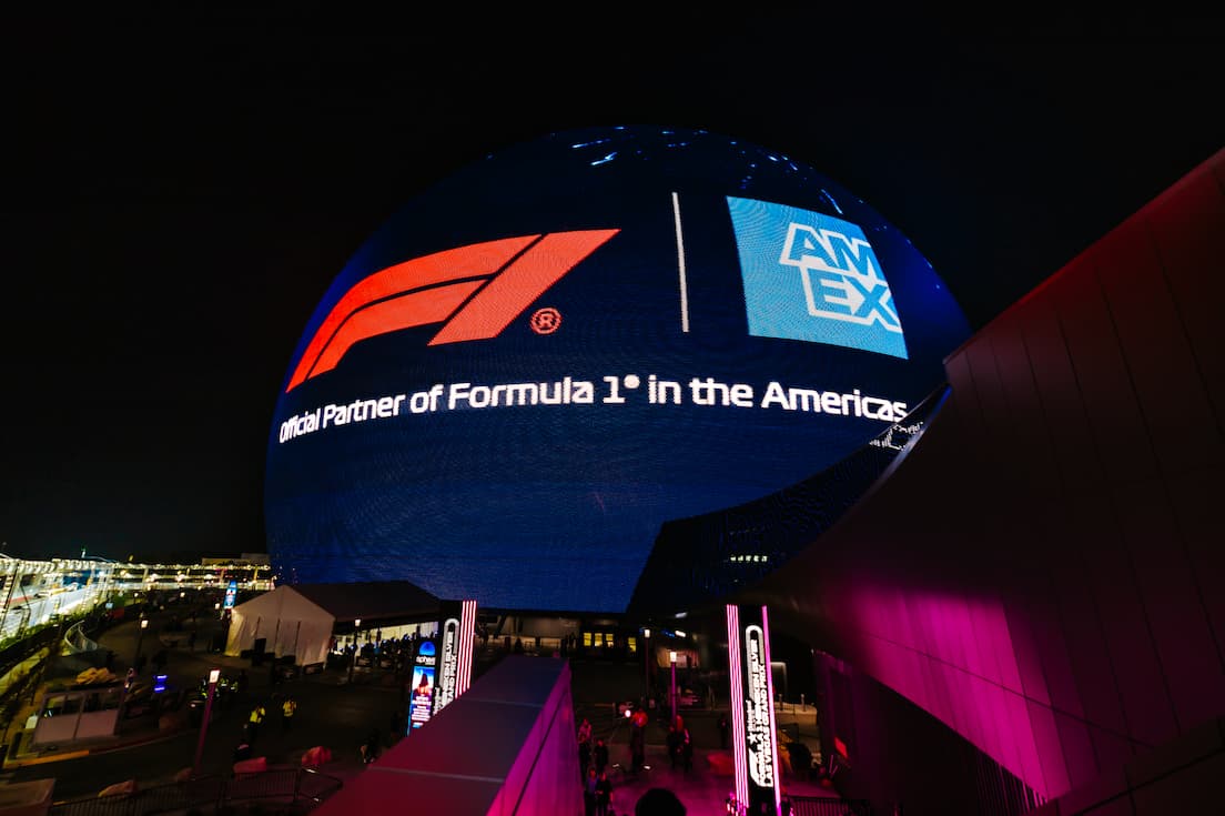 The Las Vegas Sphere at night displaying F1 and AmEx logo on a blue background